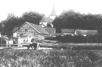 022 0021 Blick auf Petersons Einfahrt gesehen aus Richtung Kleinbahnbruecke ueber den Dorfgraben Im Hintergrund die Kirche