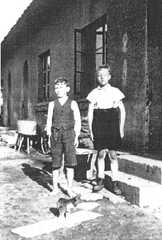 056 0032 Bruno Spauschus 1937 mit Uhrkette seinem Cousin und seiner Katze vor dem grauen Haus