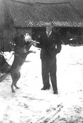 062 0011 Kurt Marquardt im Winter 1943 44 auf dem Hof mit seinem Wachhund Nero Im Hintergrund der Werkzeug und Geraeteschuppen
