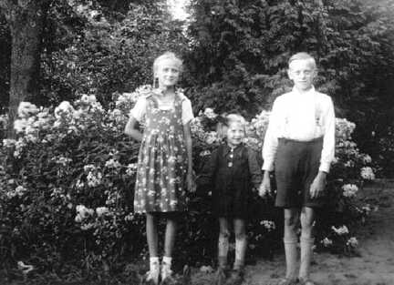 086 0054 Die Geschwister Waltraud und Erich Herbstreit im Garten Das kleine Maedchen in der Mitte gehoert nicht zur Familie