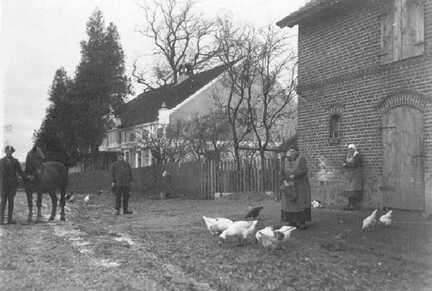 091 0001 Das Wohnhaus und Teilansicht der Stallung vom Anwesen Schlaugiess Oma Luise Schlaugiess beim Huehnerfuettern