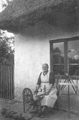 112 0006 Oma Lange vor dem Haus mit Wocken Spinnrad